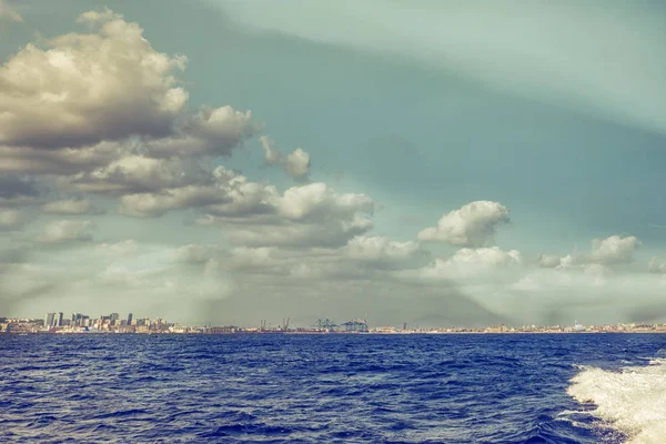 Landscape of Naples gulf on the horizon line seen by sea at sunset time, vintage mode. Soft focus with copy space for your text. Famous landmark and tourist destination. Campania, Italy.