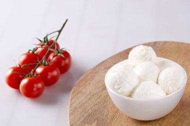 Organik kiraz domates ve mozzarella beyaz zemin üzerine seramik plaka. Üstten görünüm. Yat. yumuşak odak.