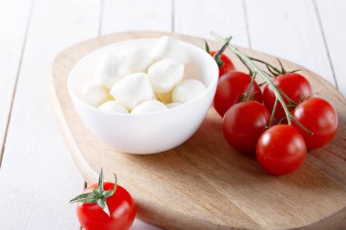 Organik kiraz domates ve mozzarella beyaz zemin üzerine seramik plaka. Üstten görünüm. Yat. yumuşak odak.