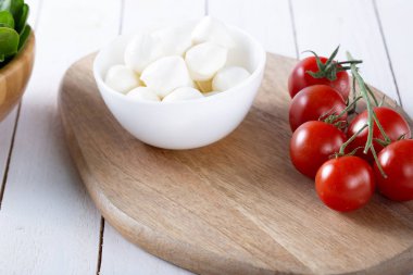 Organik kiraz domates ve mozzarella beyaz zemin üzerine seramik plaka. Üstten görünüm. Yat. yumuşak odak.