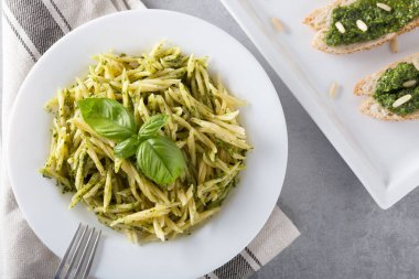 Beyaz plaka üzerinde pesto sos ile geleneksel trofie makarna