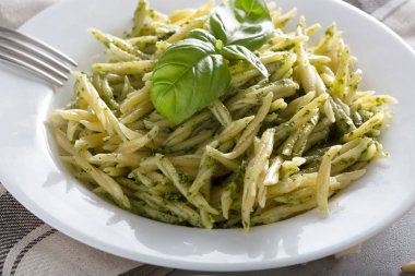 Beyaz plaka üzerinde pesto sos ile geleneksel trofie makarna