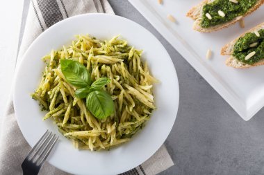 Beyaz plaka üzerinde pesto sos ile geleneksel trofie makarna