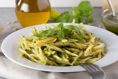 Beyaz plaka üzerinde pesto sos ile geleneksel trofie makarna
