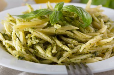 Beyaz plaka üzerinde pesto sos ile geleneksel trofie makarna