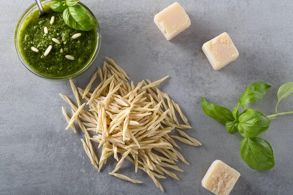 Pasta cruda trofie e una ciotola di vetro con souace al pesto — Foto Stock