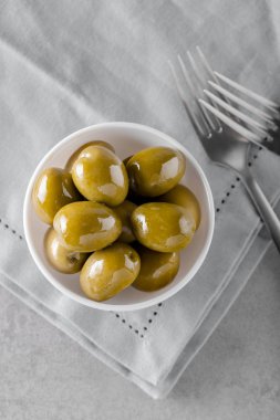 Beton arka planda konserve taze zeytin ile kase