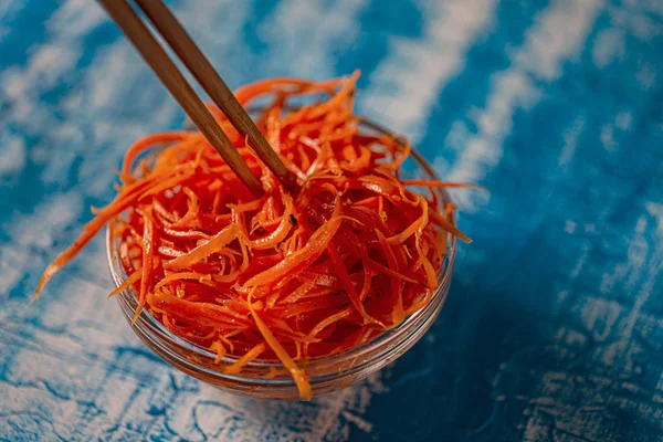 Asian carrot salad with spices and garlic on the plates.