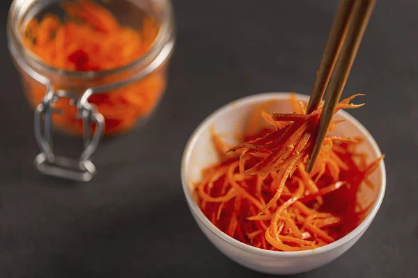 Asian carrot salad with spices and garlic on the plates.