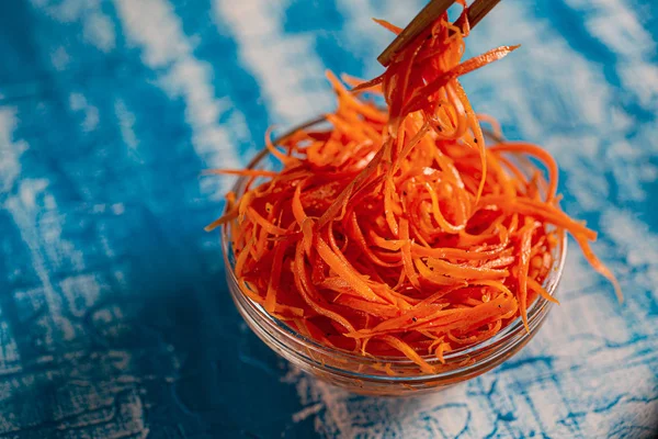 Азиатский морковный салат со специями и чесноком на тарелках . — стоковое фото