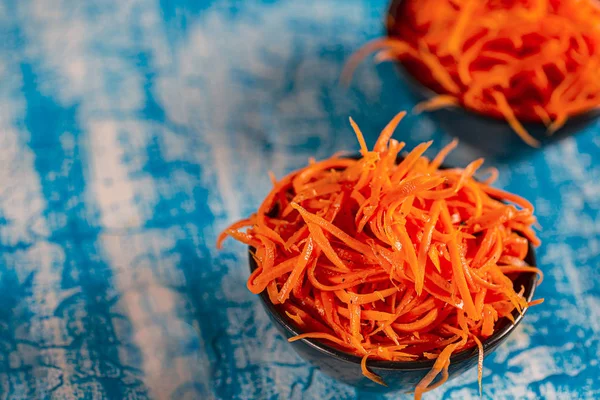 Азиатский морковный салат со специями и чесноком на тарелках . — стоковое фото