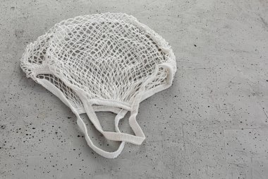 Beton bir arka planda beyaz pamuk iplik torbası