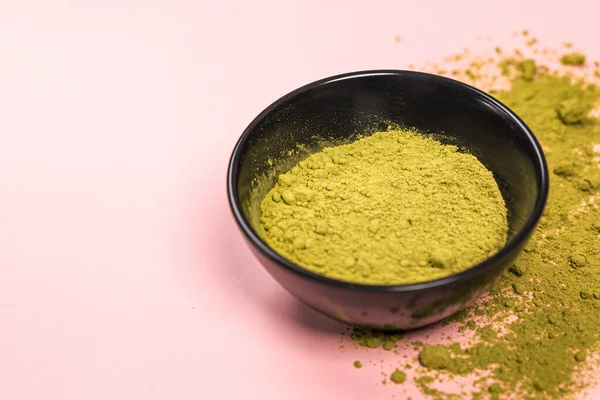 Matcha green tea powder close up on colored background