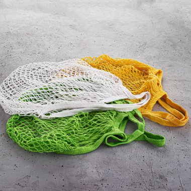 Beton bir arka planda üç adet pamuklu torba.