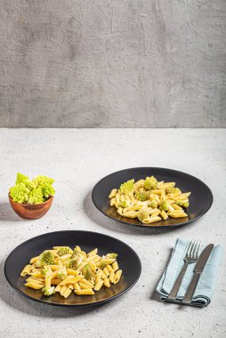 Açık gri arka planda Romanesco lahanalı Penne makarna