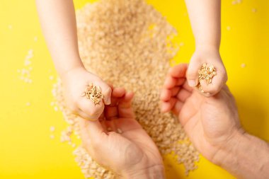 Kahvaltı için yulaf ezmesi. Sarı arka planda el ele tutuşuyorlar.