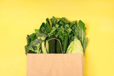 Organik sebzeler, kabak, brokoli, salatalık, lahana, hindiba, kereviz, moda sarı arka planda pişirmek için ham malzemeler. Sağlıklı, temiz yeme konsepti. Vejetaryen ya da glütensiz diyet. Uzayı kopyala Üst Manzara. Yiyecek çerçevesi