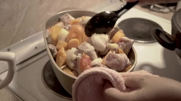 Een vrouw is goulash met gestoofde kool koken — Stockvideo