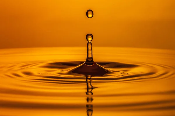 Drops of water fall into the water — Stock Photo, Image