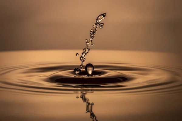 Drops of water fall into the water — Stock Photo, Image