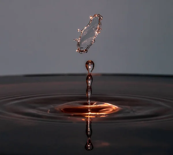 Gotas de água caem na água — Fotografia de Stock