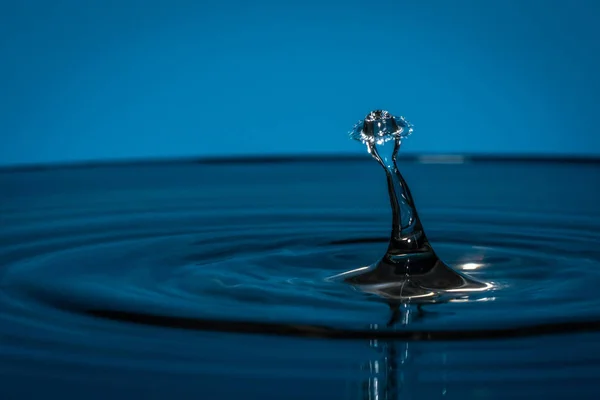 Drops of water fall into the water — Stock Photo, Image