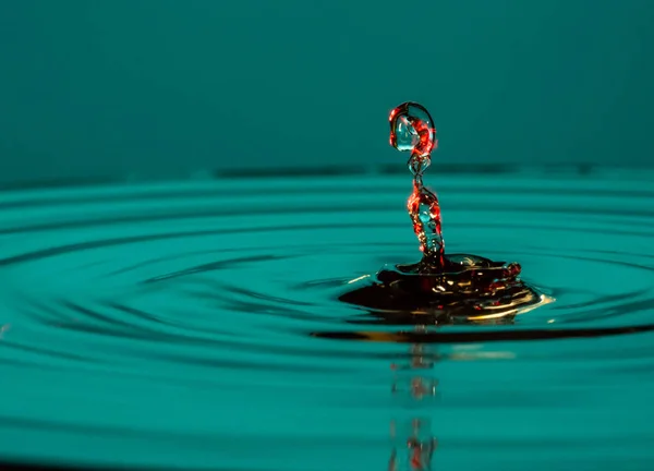 Droppar vatten falla i vattnet — Stockfoto