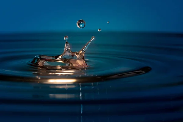Krople wody wpaść do wody — Zdjęcie stockowe