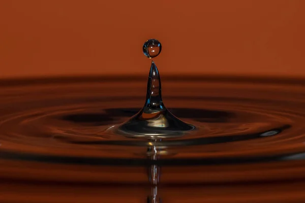 Gotas de água caem na água — Fotografia de Stock