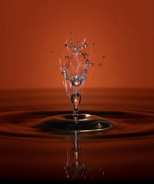 Gotas de água caem na água — Fotografia de Stock