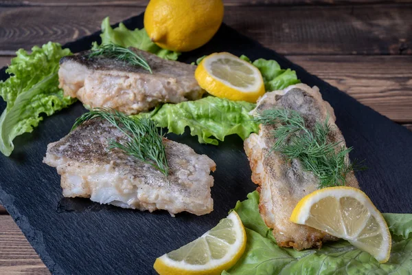 Fried fish with lemon and lettuce leaves — Stock Photo, Image