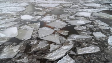 günbatımı gökyüzü yansıması ile bir kış nehir üzerinde kırık buz