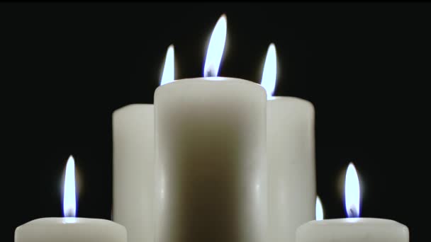 Ein paar Kerzen brennen auf schwarzem Hintergrund. — Stockvideo