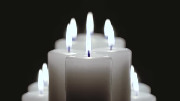 Ein paar Kerzen brennen auf schwarzem Hintergrund. — Stockvideo