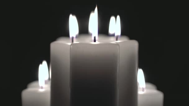 Kilka świece palą się na czarnym tle. — Wideo stockowe