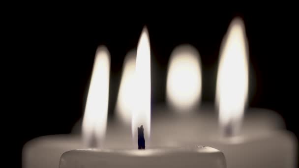 Alcune candele stanno bruciando su uno sfondo nero . — Video Stock