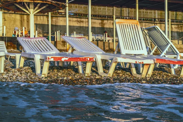 Ξαπλώστρες δίπλα στη θάλασσα κατά τη διάρκεια του ηλιοβασιλέματος — Φωτογραφία Αρχείου