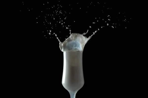 Milk shake splashes from a glass. Isolated image on black background. — Stock Photo, Image