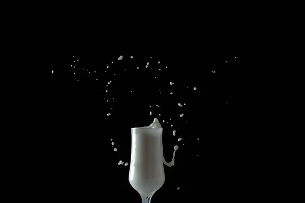 Batido de leche salpica de un vaso. Imagen aislada sobre fondo negro . — Foto de Stock