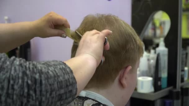 Un giovanotto taglia i capelli in un negozio di barbiere. Da vicino. — Video Stock