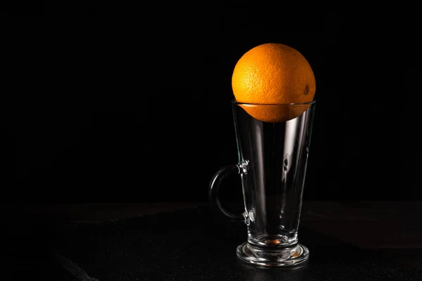 Jus d'orange dans un verre sur fond noir — Photo