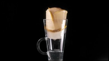Dondurulmuş dilimlenmiş limon bir bardakta erir. Zaman atlamalı