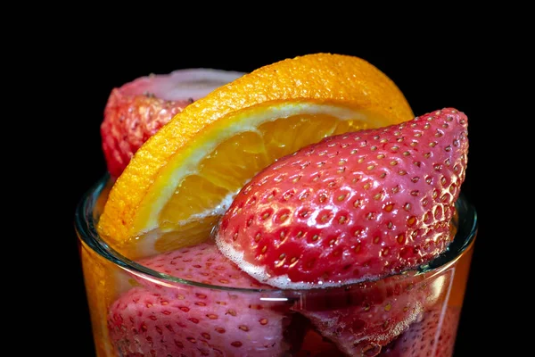 Jahody s pomerančovníky ve sklenici vody — Stock fotografie