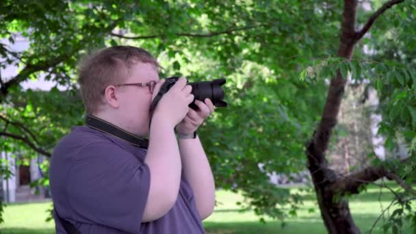 Young man takes pictures in the park — 비디오