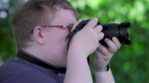 Mladý muž fotí v parku — Stock video