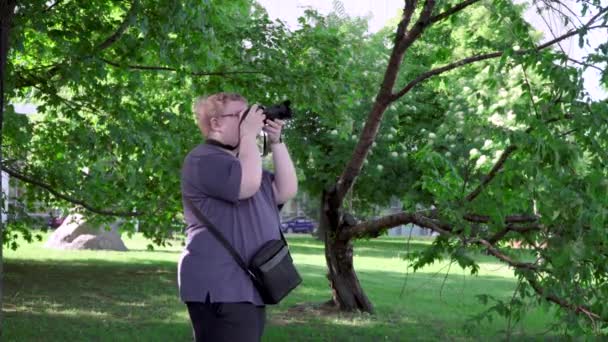 Genç adam parkta fotoğraf çekiyor. — Stok video