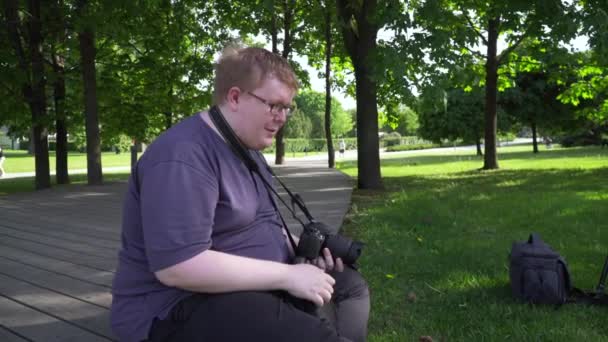 Joven toma fotos en el parque — Vídeos de Stock