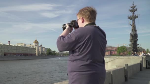 Молодий чоловік фотографує в парку — стокове відео