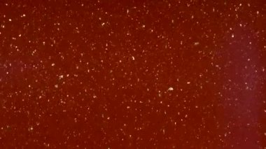 Küçük parçacıklar renkli bir arka plan üzerinde rasgele hareket.