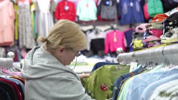 Mulher Escolhe Roupas Loja — Vídeo de Stock